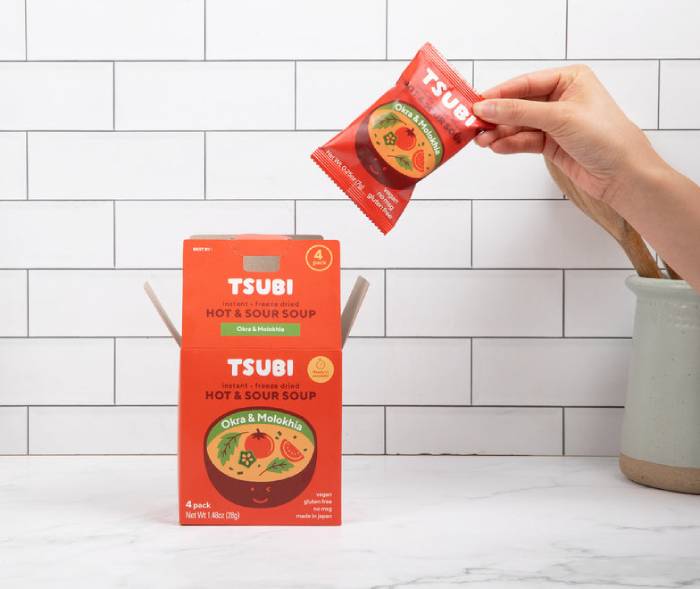 hand holding a packet of hot and sour tomato soup mix